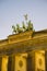 Detail of sculptures on top of Brandenburger Tor in Berlin with pink evening light and soft clouds, Germany