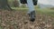 Detail on shoes and steps. Caucasian blond woman slomo walking toward fall woods touching tree. Following behind gimbal