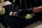 Detail shot of a chef slicing fresh soybean sprouts on a black cutting board