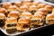 detail shot of mini bbq sliders with cheese on a metal tray