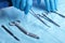 Detail shot of sterilized surgery instruments with a hand grabbing a tool ,