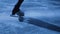 Detail shot of women's legs in figure skating skates sliding on cold ice in arena. A professional sportswoman trains