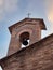 Detail of a Small Iron Bell under a Masonry Arch of a Church in the Medieval Tuscan Town of San Gimignano - Italy