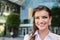 Detail of smiling businesswoman against glassy modern office building