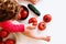 Detail of some ripe red tomatoes between the legs of a girl who plays with them, white background