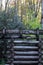 Detail of a stacked log support for a water sluice, autumn leaves and rhododendrons