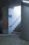 Detail of a staircase in a train station with the orange ticket validation machine next to it