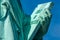 Detail of Statue of Liberty against blue sky, book with the date of USA\\`s independence. New York City , United States