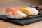 Detail of steamed prawn nigiri, with background of nigiri with Pacific Sea Urchin, steamed salmon, steamed shrimp, caviar, roasted