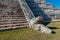 Detail of the steps and a serpent head sculpture of the pyramid Kukulkan in the Mayan archeological site Chichen Itza