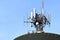 Detail of the telecommunication tower on the roof of a palace with the blue sky. Telecommunication tower with antennas and