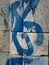 Detail of textured grey masonry blue and white graffiti