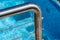 Detail of thermal swimming pool tiled stairs down water and metal handle