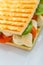 Detail of toast sandwich with vegetables and mozarella on white plate