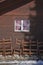 Detail of traditional wooden swiss house and group of wooden chairs outdoors