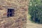 Detail of traditionaly built window in stone building with metal bars.