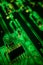 Detail of a transistor array, resistors and capacitors soldered to a green glowing PCB