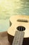 Detail of ukulele with swimming pool at the background