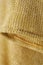 Detail of vest knitted in thin ochre colored thread
