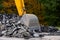 Detail view of a big excavator used to destroy old asphalt road on a mountain road.