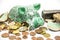 Detail view of green broken piggy bank, euro coins scattered around, hammer next to it.