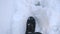 Detail view on male feet walking on snowy trail. Guy in boots going on road stepping on white clear snow. Unrecognizable