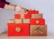 Detail view of woman person hands stacking Christmas presents in a pile.