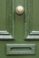 Detail of vintage green wooden door with brass doorknob knocker