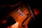 Detail of a violin on a blurry dark background, selected focus a