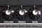 Detail of the volume, treble and bass control knobs of a guitar amplifier, equalization dials close up, selective focus