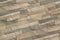 Detail of a wall of a long gray and brown brick. The facade of the building, built of natural stone. Background textur