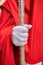 Detail of the white gloved hand of a Nazarene or penitent, holding a silver wand of command. selective focus with focus only on
