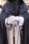 Detail of the white gloved hand of a Nazarene or penitent, holding a silver wand of command. selective focus with focus only on