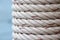 Detail of white ship rope wrapped around the pole at fishing port