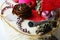 Detail of winter christmas decoration with trumpet shaped silver painted piece of wood, red fabric, shiny beads, cones and lichen