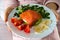 Detail of woman in bathrobe on bed with hands holding a plate with fit healthy meal, food include omega-3 fatty acid fish