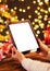 Detail of woman hand holding tablet with Christmas background