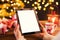 Detail of woman hand holding tablet with Christmas background