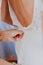 Detail of woman`s hand helping to close zipper on wedding dress
