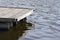 Detail of a wooden pier in dark water. Wooden dock detail.