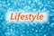 Detail of word `Lifestyle` on a shiny blurred blue background.