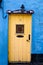 Detail of a yellow door of a blue house in the coastline village of Kinsale