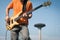 Detail of a young musician playing bass guitar