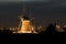 Detailed capture of a dutch windmill illuminated by lights in the evening