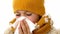 Detailed close up of a sick young girl blowing her nose into a tissue in a focused shot