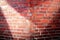 Detailed close up view at a red brick wall with multiple spotlights on it