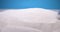 detailed extreme close-up digging white sand with mini shovel on blue background