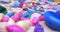 Detailed extreme close-up of multicolored seashells and polished glass pebbles on white sand