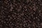 Detailed full frame top view of dark brown coffee beans