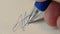 Detailed macro shot of a person\'s fingers holding a blue ballpoint pen and signing a document, symbolizing personal